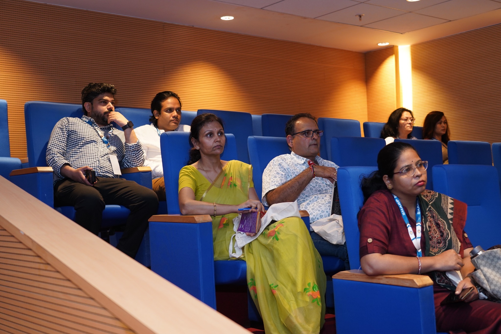 Delegates follow the conference proceedings in the auditorium.